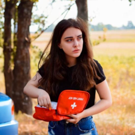 Une femme utilisant une trousse de secours pour sa voiture