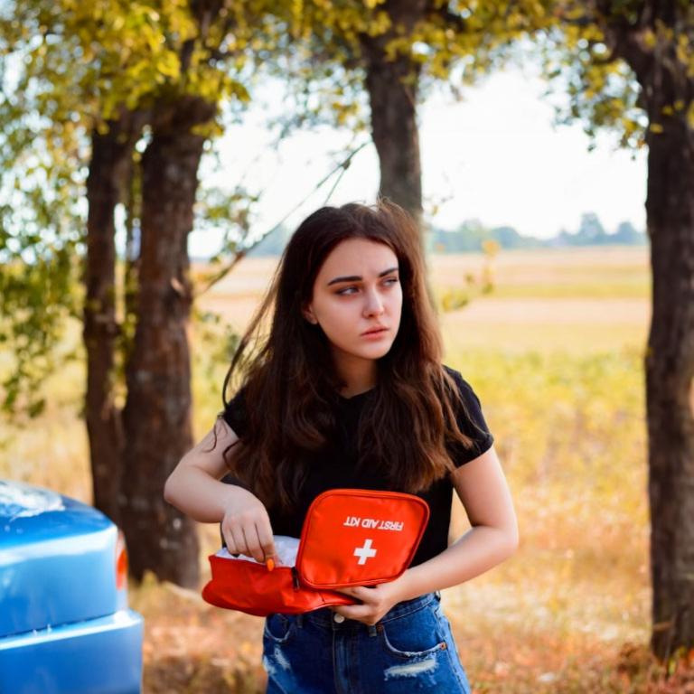 Une femme utilisant une trousse de secours pour sa voiture